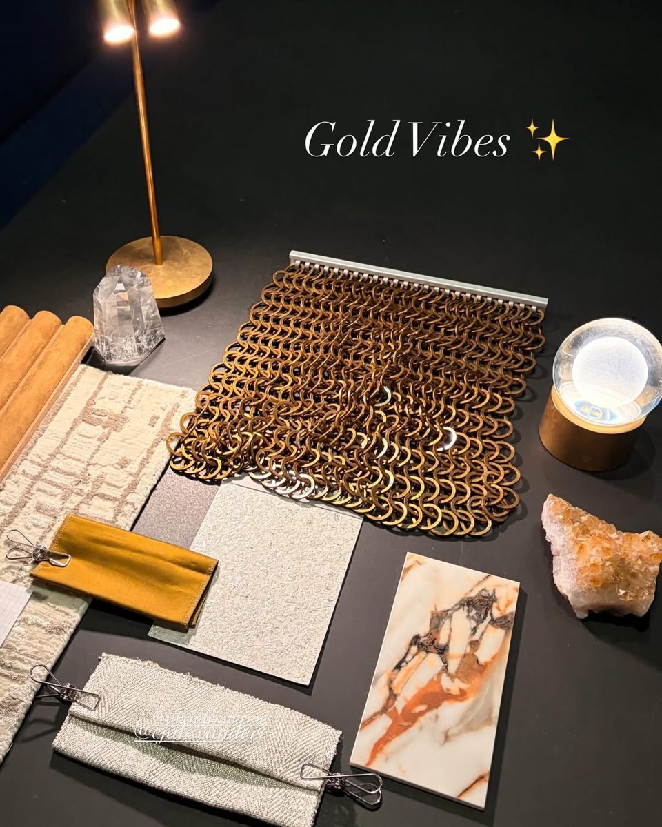 A layered interior design palette of warm metals, neutral textures, and fabric samples